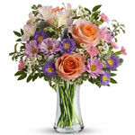Clear tall glass vase arrangement of peach/apricot roses, soft pink alstroemeria, mid pink mini carnations, lavender asters & da