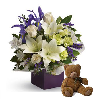 Gorgeous white lilies and delicate blue iris dance gracefully with roses and alstroemeria in this luxurious arrangement, + teddy