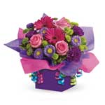 Let's get this party started! This festive arrangement is flowers and a present in one. 