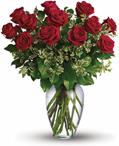 Stunning in its simplicity, this elegant vase arrangement of deep red roses and rich green foliage makes quite an impression.